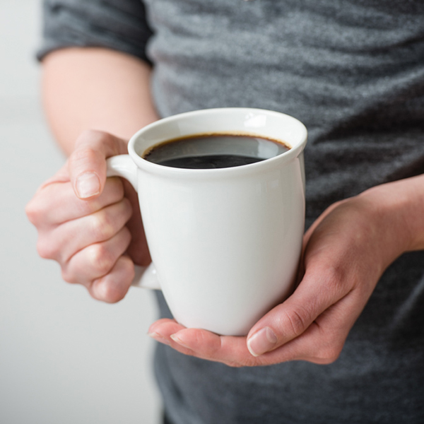 a cup of coffee in a woman's hands