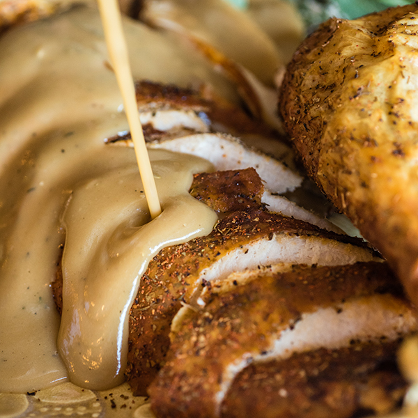 carved turkey with gravy being poured on top