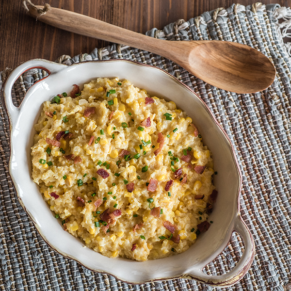 slow cooker corn casserole with a serving spoon